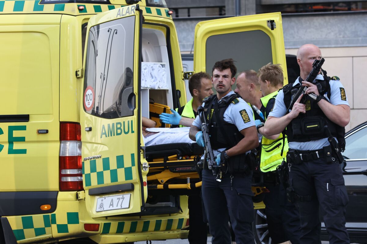 An ambulance and armed police outside the Field's shopping center, in Orestad, Copenhagen, Denmark, Sunday, July 3, 2022, after reports of shots fired. Danish police say several people have been shot at a Copenhagen shopping mall. Copenhagen police said that one person has been arrested in connection with the shooting at the Field’s shopping mall on Sunday. Police tweeted that “several people have been hit” but gave no other details. (Olafur Steinar Gestsson /Ritzau Scanpix via AP)