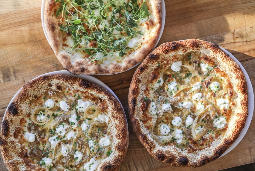 Tribute Pizza honors three pizzas from Brooklyn, including the Brooklyn’s Best (bottom two), which has a crazy-good sesame seed crust. 