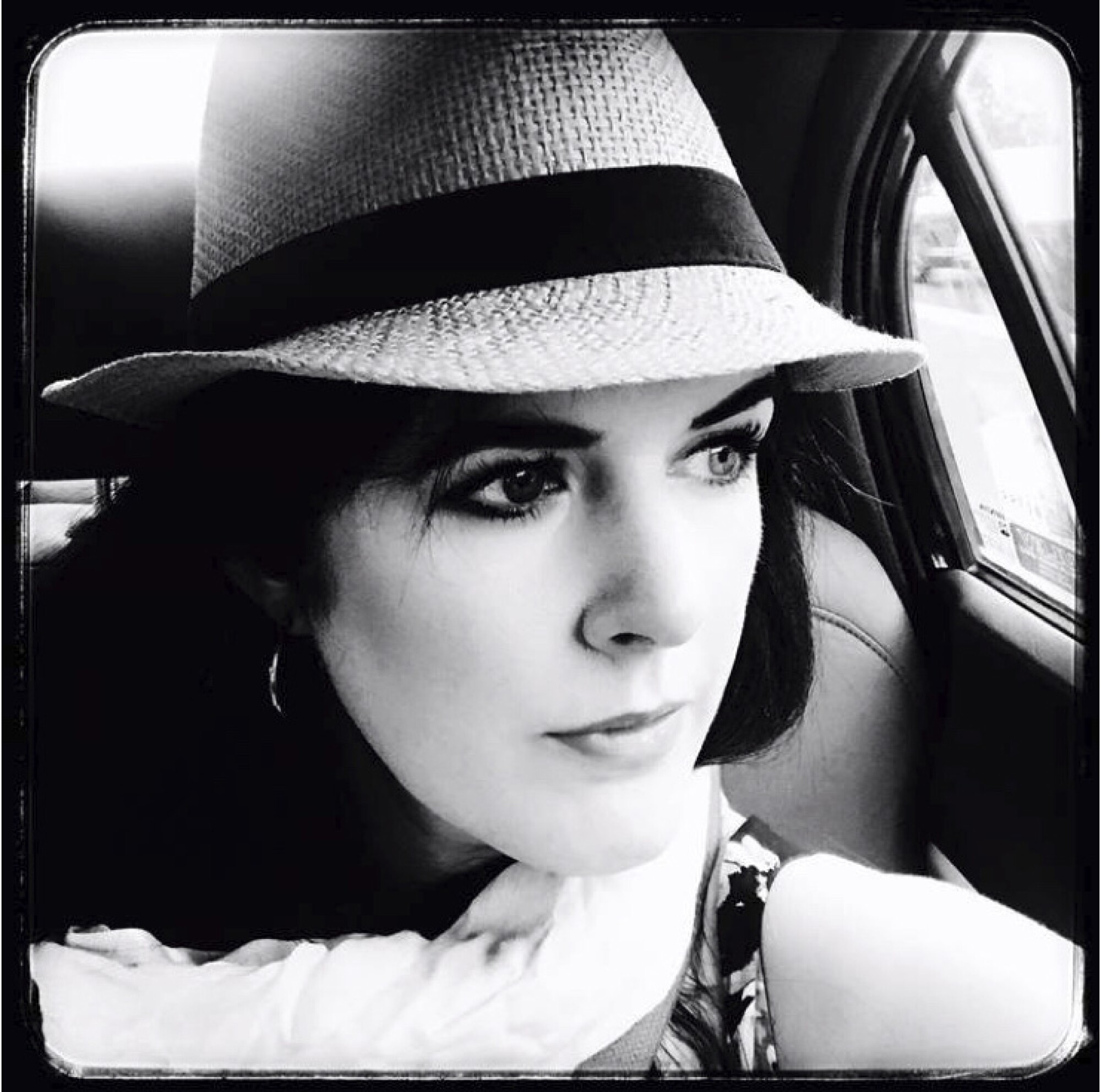 A black-and-white photo of a woman in a fedora.