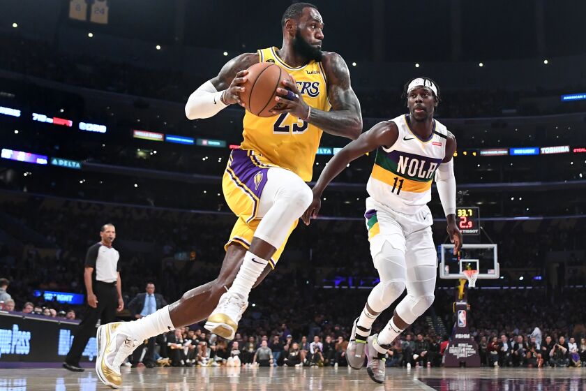 LOS ANGELES, CALIFORNIA FEBUARY 25, 2020-Lakers LeBron James drives to the basket on Pelicans Jrue Holiday in the 2nd quarter at the Staples Center Tuesday. (Wally Skalij/Los Angeles Times)