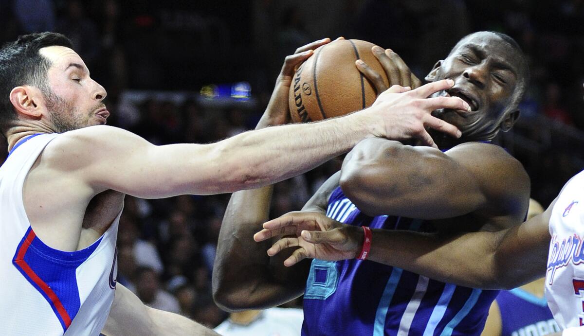 J.J. Redick gets his hand in the face of Charlotte center Bismack Biyombo during the Clippers' 99-92 win Tuesday over the Hornets. Redick had 23 points, three rebounds and three assists in the win.