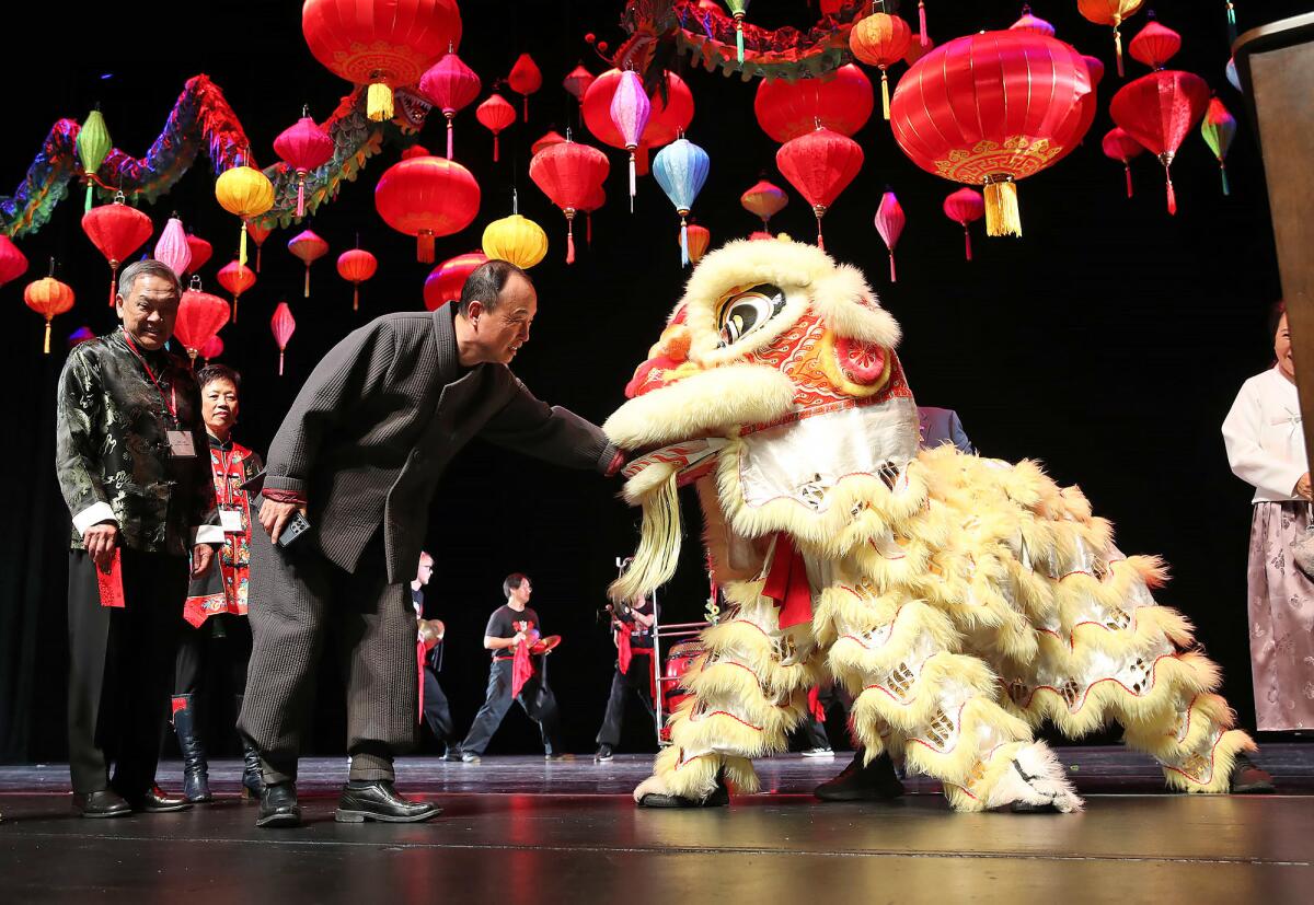 A guest greets one of the lions of the Gio Nam Lion Dance team.