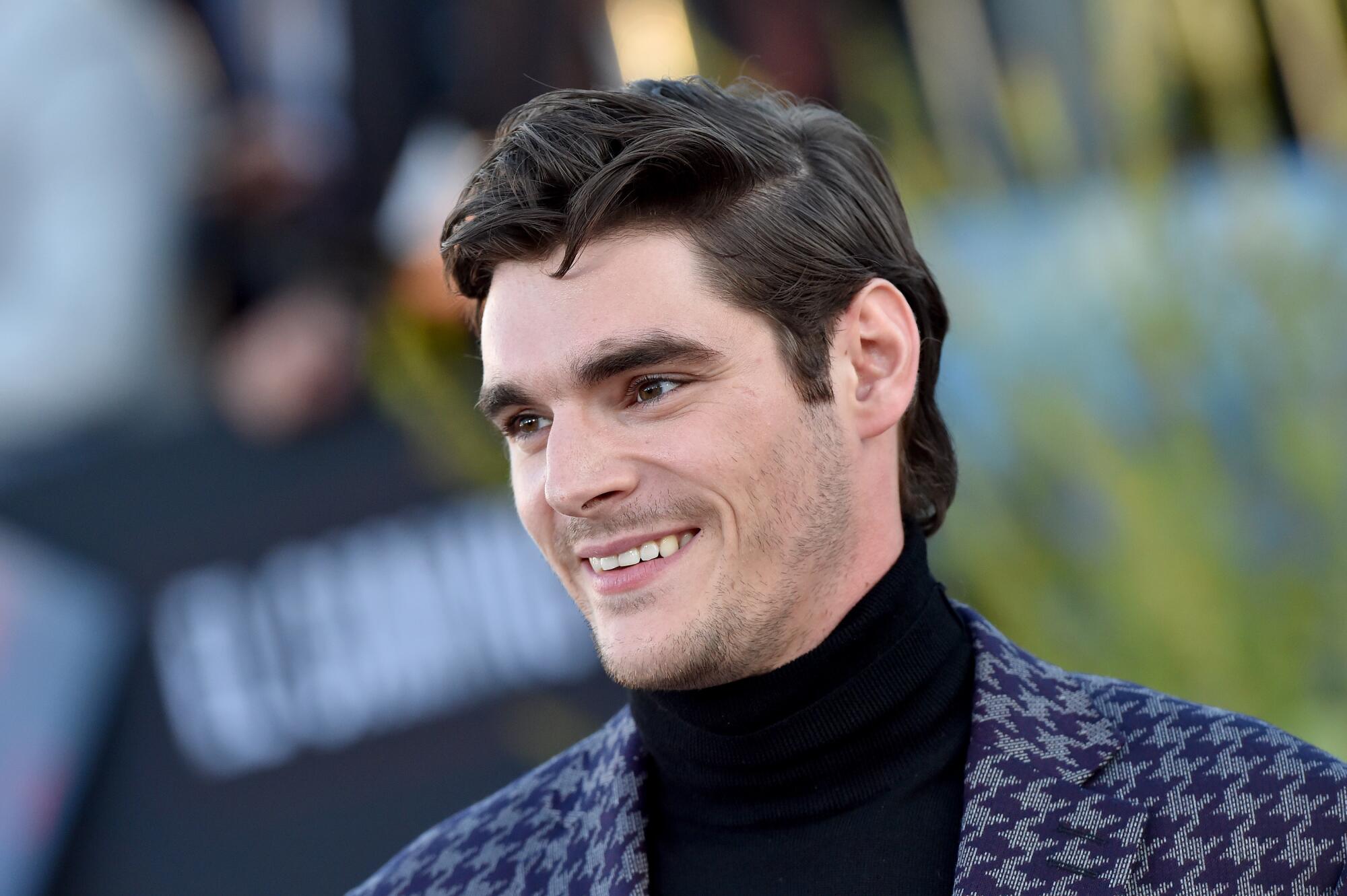 A head-and-shoulder frame of smiling RJ Mitte looking off to the left.