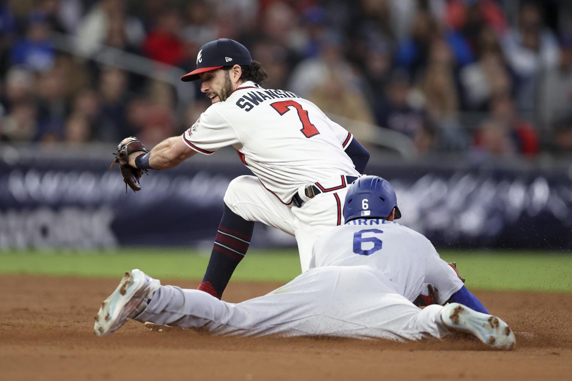 Dodgers' Trea Turner slides into second ahead of the tag by Braves shortstop Dansby Swanson to steal second base