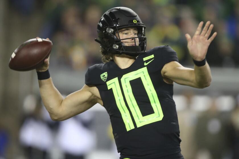 File-This Nov. 17, 2018, file photo shows Oregon quarterback Justin Herbert throwing down field against Arizona State during the first quarter of an NCAA college football game in Eugene, Ore. Herbert says hell return for his senior season. Herbert announced his decision on Wednesday, Dec. 26, 2018, before the Oregon left Eugene for the Redbox Bowl. Oregon plays Michigan State on Monday. (AP Photo/Chris Pietsch, File)