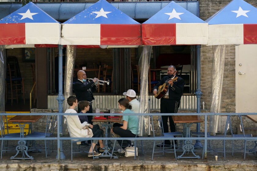 FILE - In this March 3, 2021, file photo, mariachi perform for diners at a restaurant on the River Walk in San Antonio. U.S. employers added a surprisingly robust 379,000 jobs in February in a sign the economy is strengthening as virus cases drop, vaccinations ramp up, Americans spend more and states ease business restrictions. Texas joined some other states in announcing it will fully reopen its economy. (AP Photo/Eric Gay, File)