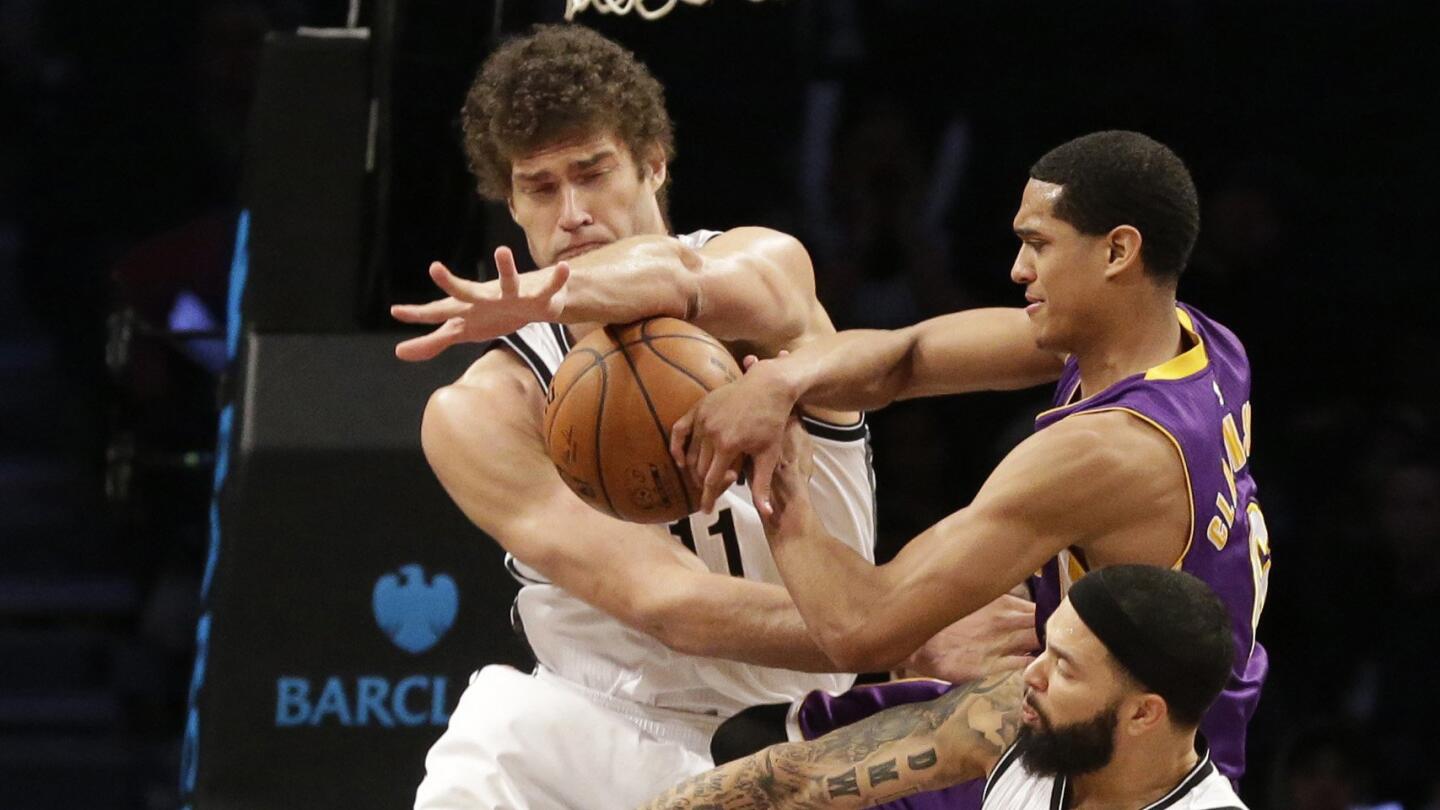 Brooklyn Nets center Brook Lopez and guard Deron Williams, bottom, fight for a rebound with Lakers guard Jordan Clarkson during the Lakers' 107-99 loss on March 29, 2015.