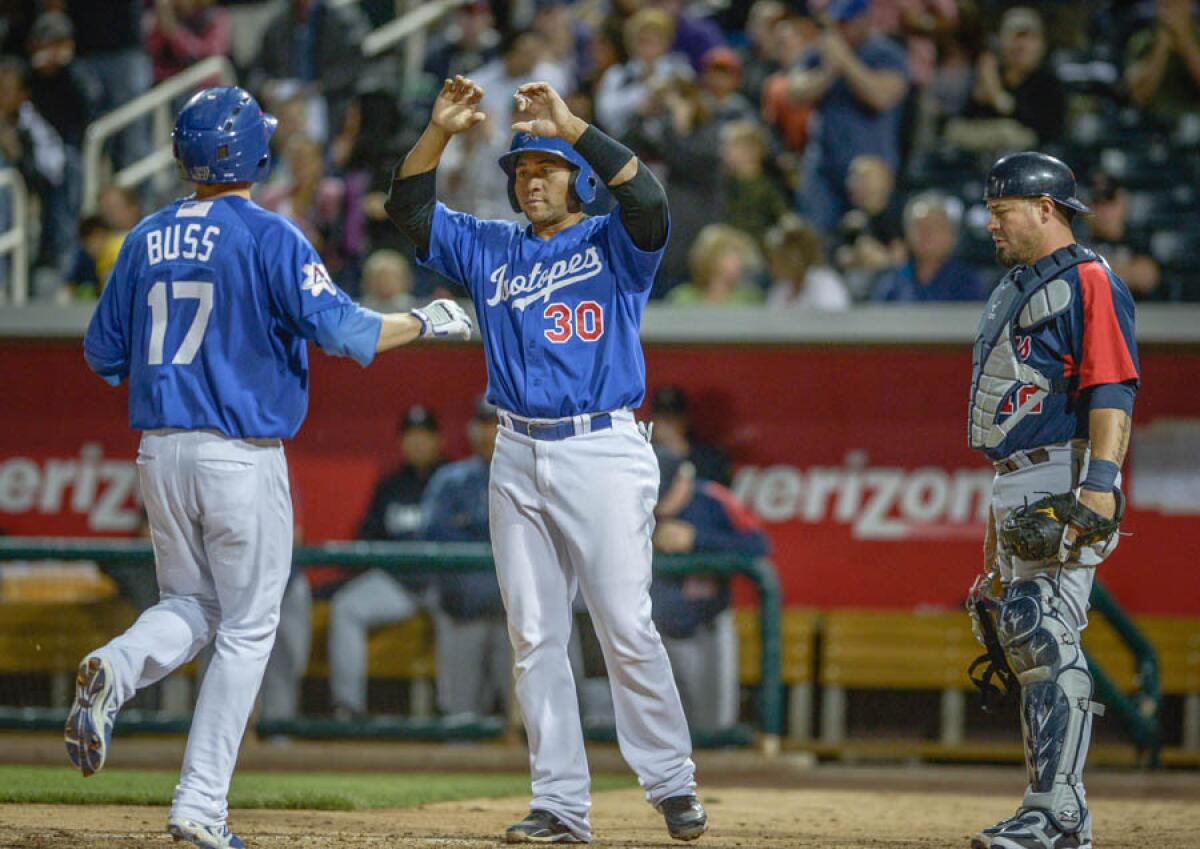 Miguel Olivo (30) of Albuquerque congratulates Nick Buss after Buss' homer against the Tacoma Rainiers.