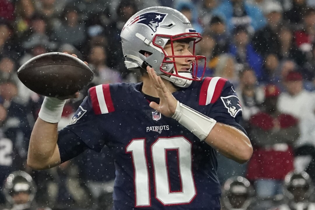New England Patriots quarterback Mac Jones looks to pass.