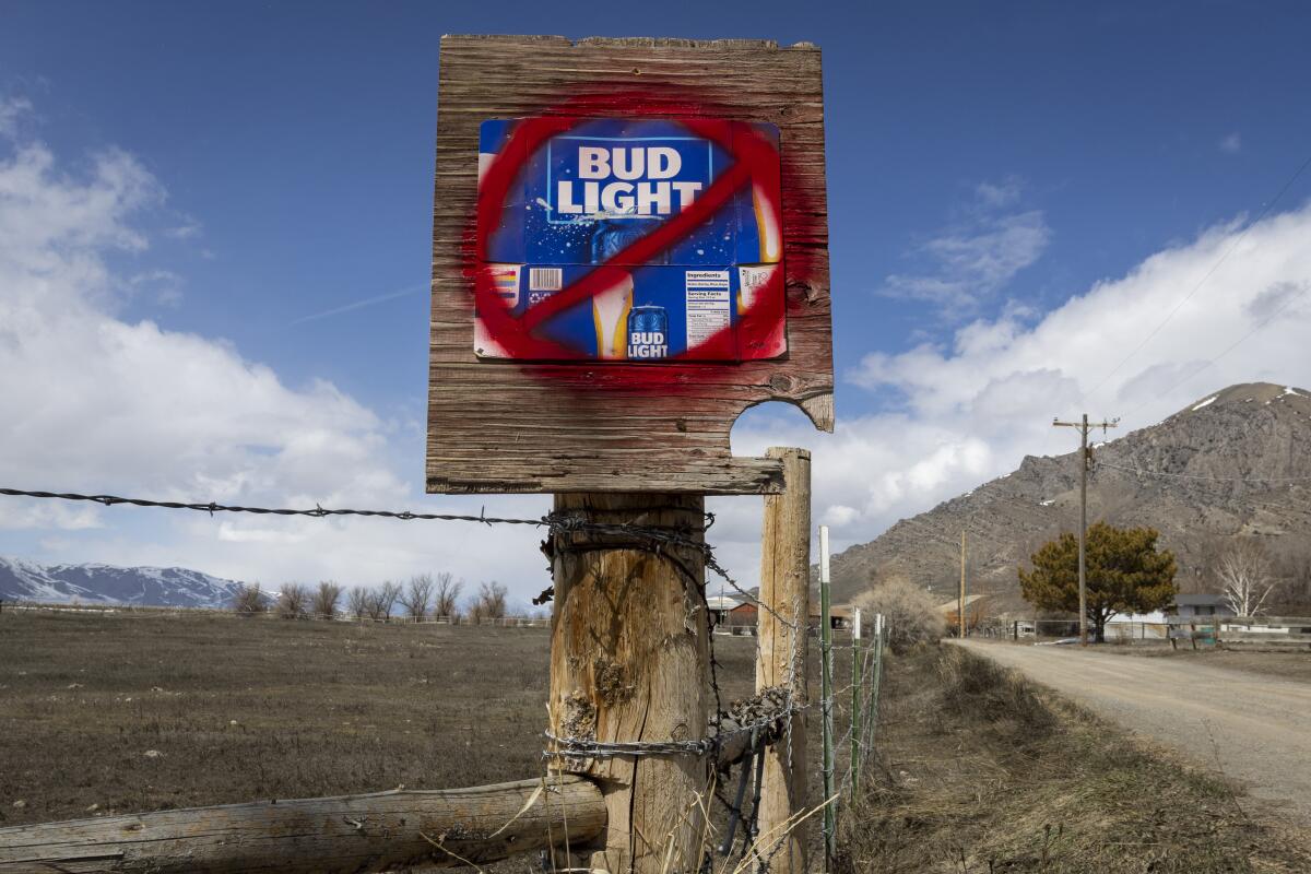 A Bud Light beer sign with a slash through it on a country road 