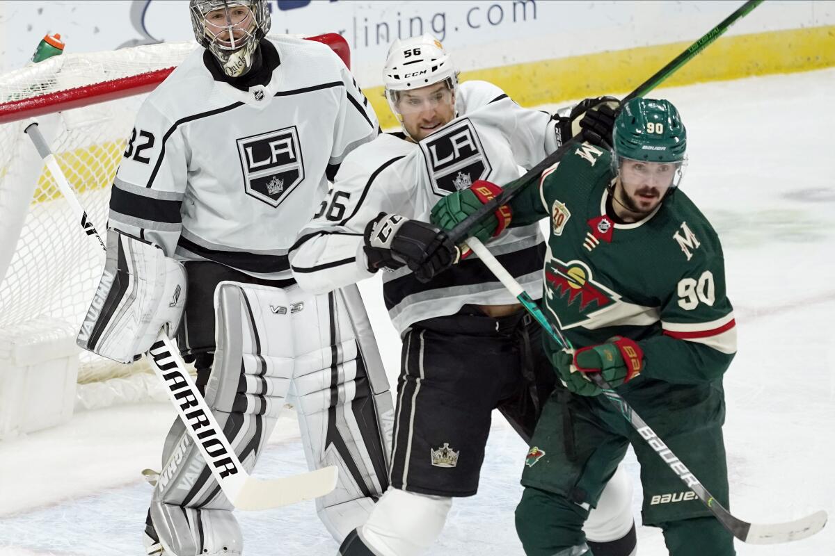 Minnesota Wild's Marcus Johansson shoves back Kings' Kurtis MacDermid as Kings goalie Jonathan Quick minds the net.