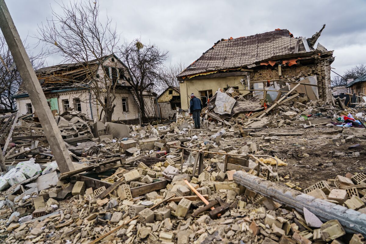 Local residents help clear the rubble of a home that was destroyed by a suspected Russian airstrike, 