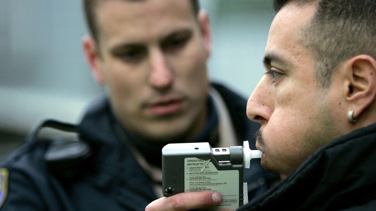 A California Highway Patrol officer administers a Breathalyzer test at a sobriety checkpoint in San Francisco.