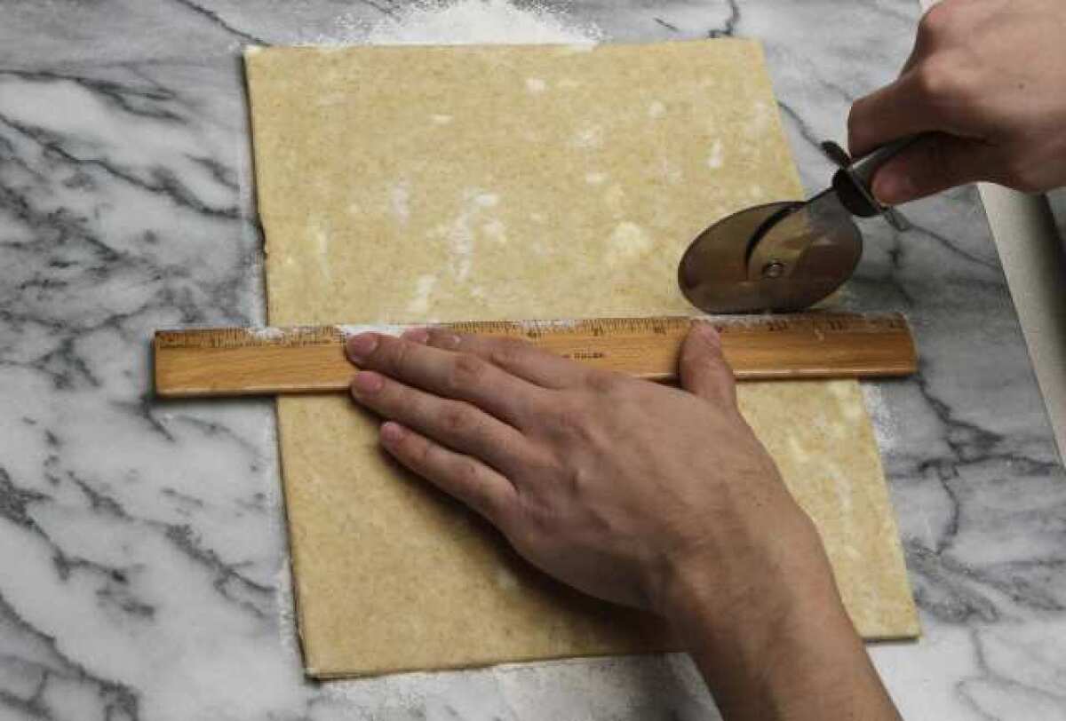 Measuring and cutting dough with a ruler.