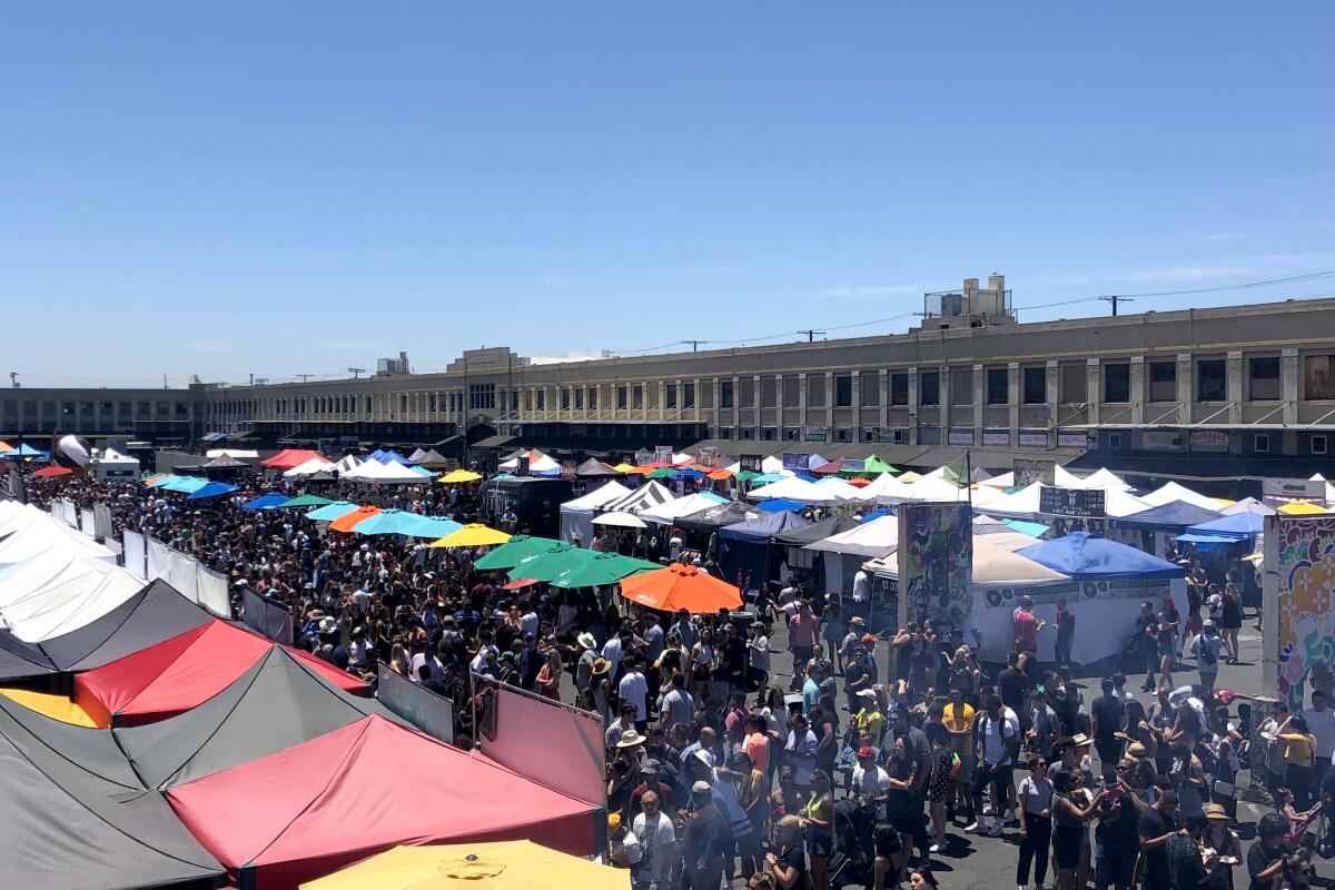 Shoppers crowd an outdoor market.