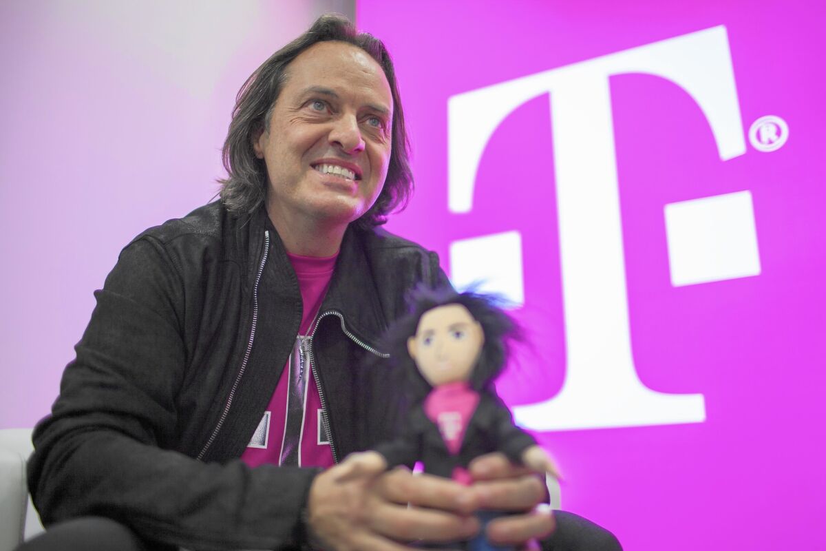 T-Mobile CEO John Legere holds a doll made in his likeness during a media event in San Francisco. WeWork is interested in Legere as a potential replacement for ousted CEO Adam Neumann.