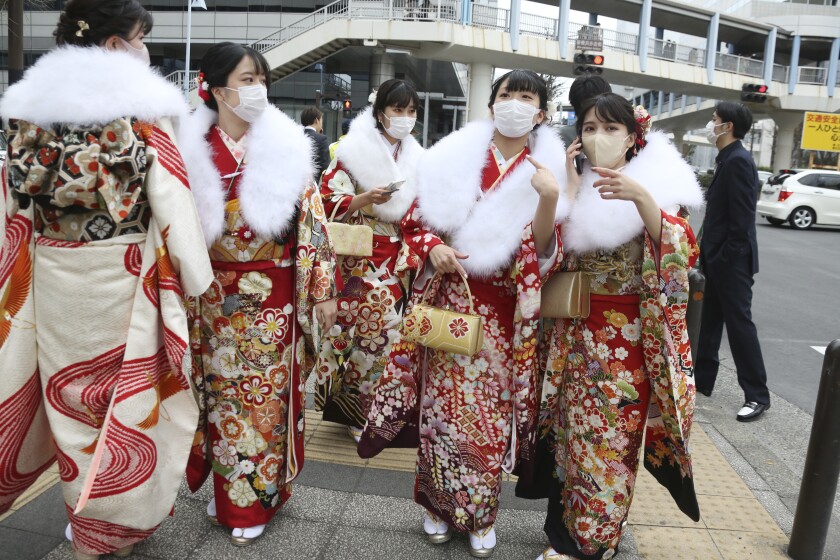 Women clad in Japan's traditional kimono outfits, who have just turned or will be 20 years old this year, walk on the street as they celebrate Coming of Age Day in Yokohama Monday, Jan. 10, 2022. (AP Photo/Koji Sasahara)