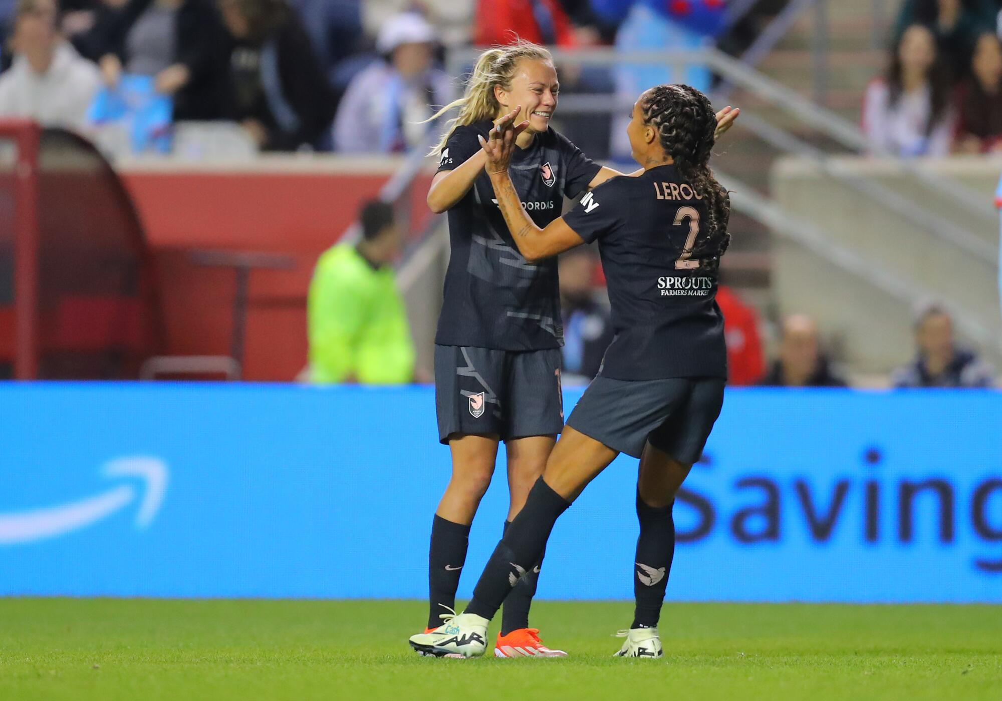 La delantera del Angel City FC Claire Emslie celebra con la delantera Sydney Leroux.