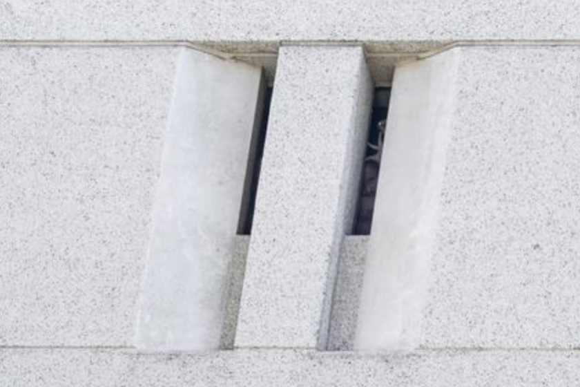 Un hombre saluda a la gente desde detrás de una ventana oscura del Centro de Detención Metropolitano en el centro de Los Ángeles, California, EE. UU., el 14 de julio de 2019. EFE/EPA/Etienne Laurent/Archivo