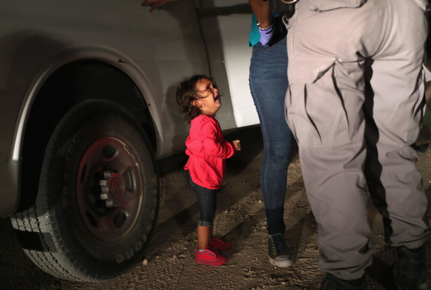 A 2-year-old cries as her mother is searched near the U.S.-Mexico border in McAllen, Texas.