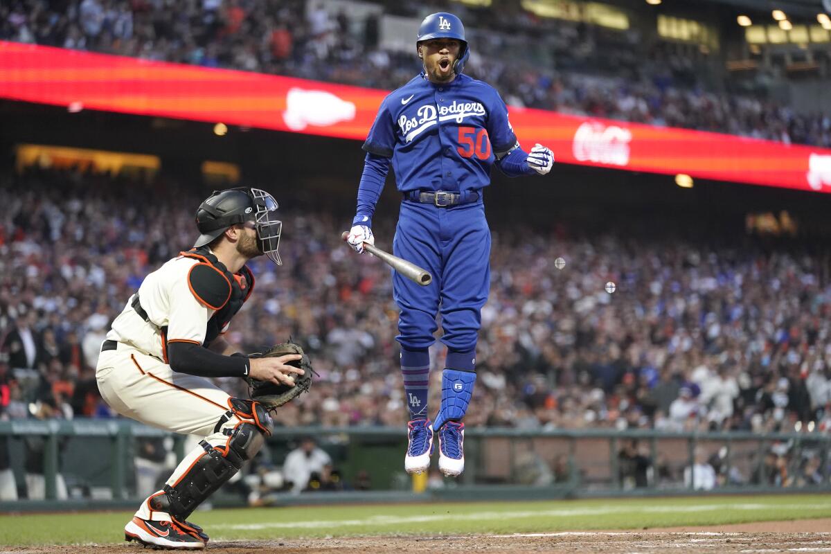 A Dodgers player jumps in the air in the batter's box