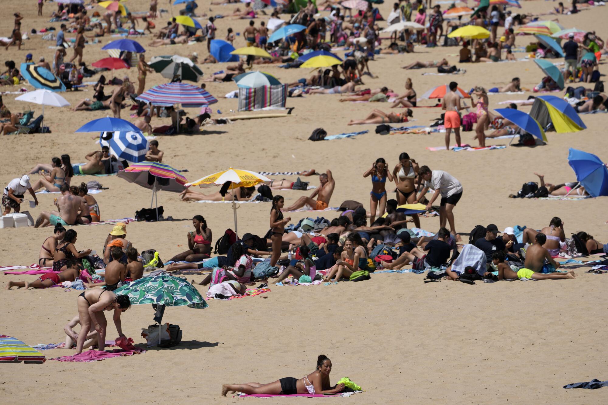 People enjoy the beach in Oeiras, just outside Lisbon, Wednesday, July 19, 2023.