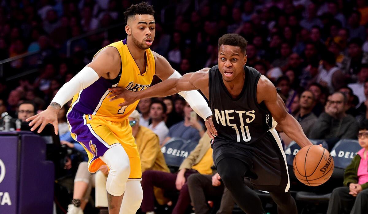 Lakers guard D'Angelo Russell defends against the Brooklyn Nets' Yogi Ferrell in a game Nov. 15. Russell will sit out the Lakers' games on Tuesday and Wednesday nights because of a sore knee.