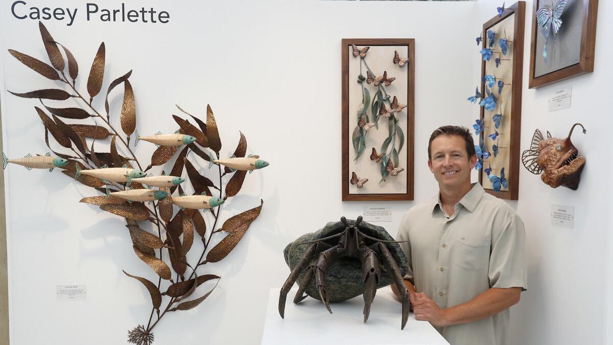 Artist Casey Parlette of Laguna Beach, known for his ocean wildlife sculptures, stands at his booth at the Festival of Arts grounds in Laguna Beach. The festival opens to the public Friday.