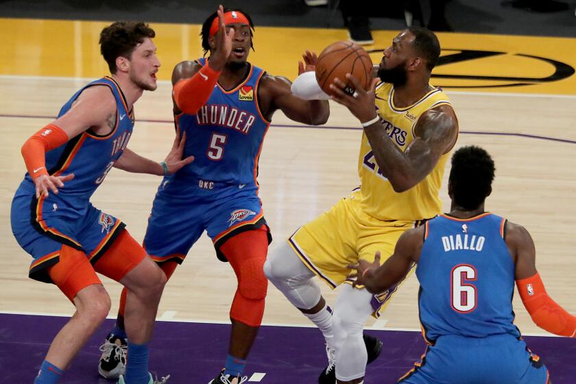 LOS ANGELES, CA. - FEB. 10, 2021. Lakers forward LeBron James goes to the basket against a trio of Thunder defenders in the first quarter of a game at Staples Center in Los Angeles on Wednesday night, Feb. 10, 2021. (Luis Sinco/Los Angeles Times)