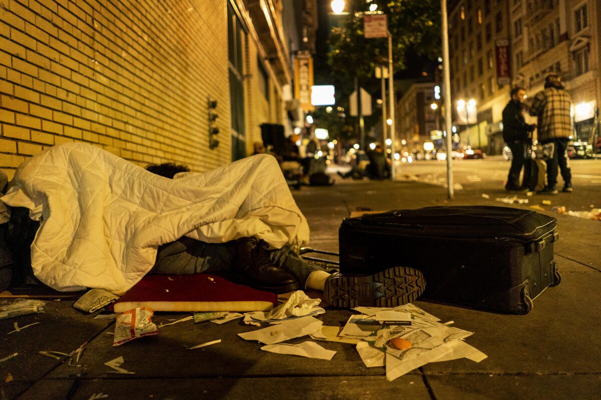 A homeless person sleeps on Ellis Street in the Tenderloin neighborhood of San Francisco.