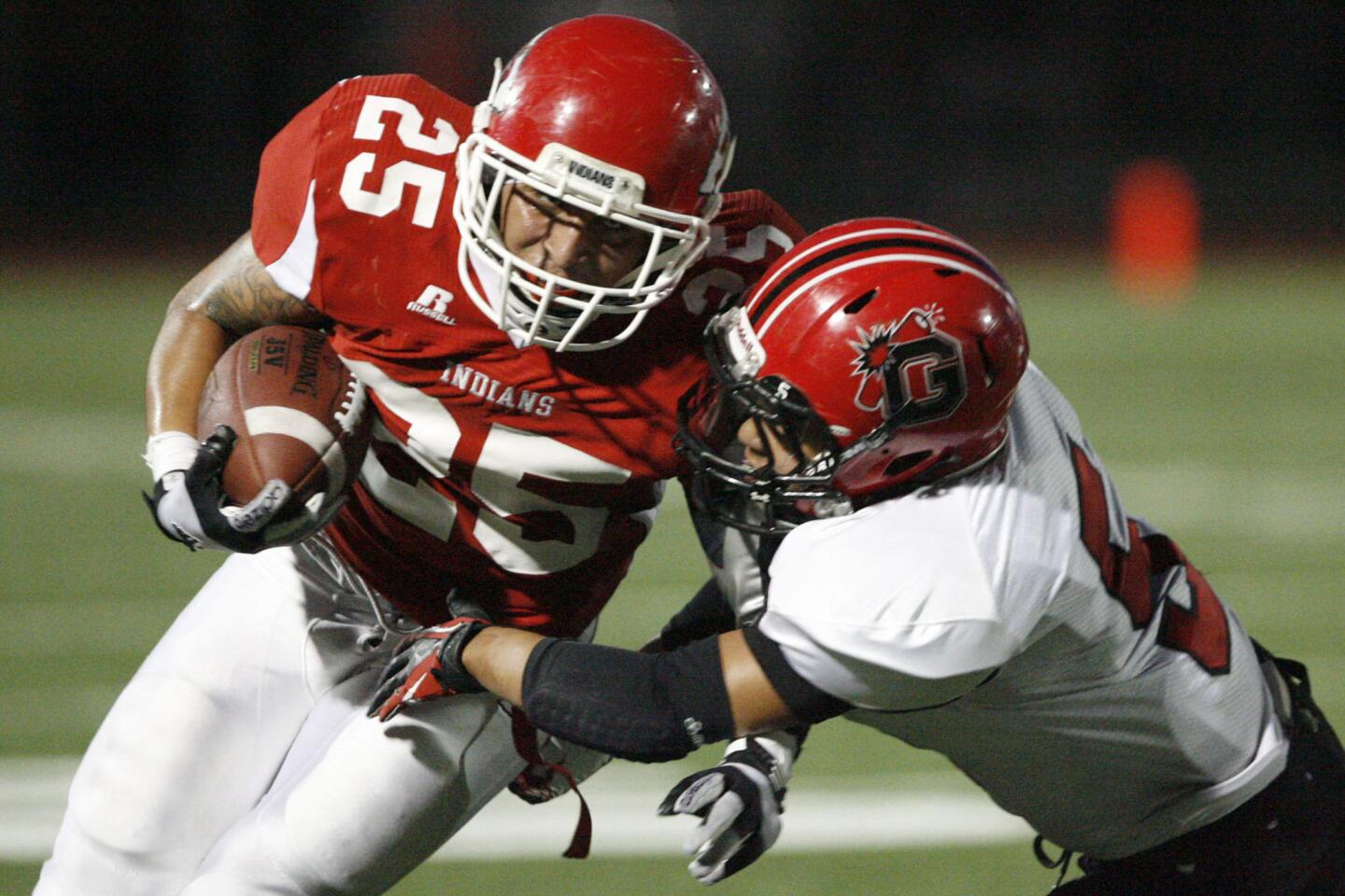 Burroughs' Israel Montes, left, gets tackled by Glendale's Carlo Maquiddang during a game at John Burroughs High School in Burbank on Thursday, September 27, 2012.