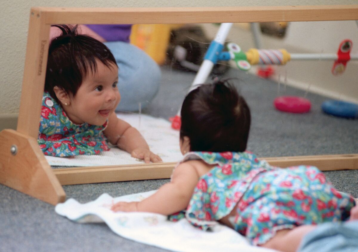 Un bebé de 4 meses intenta centrar su atención en un espejo