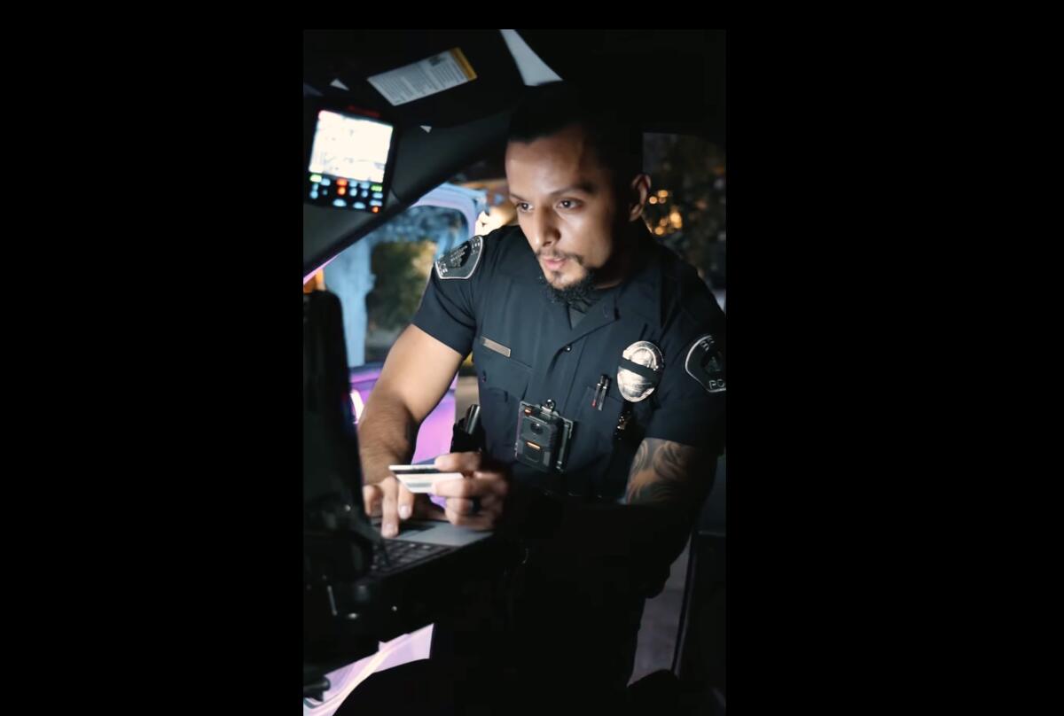 A Brea police officer with tattoos on his left arm uses a computer. 