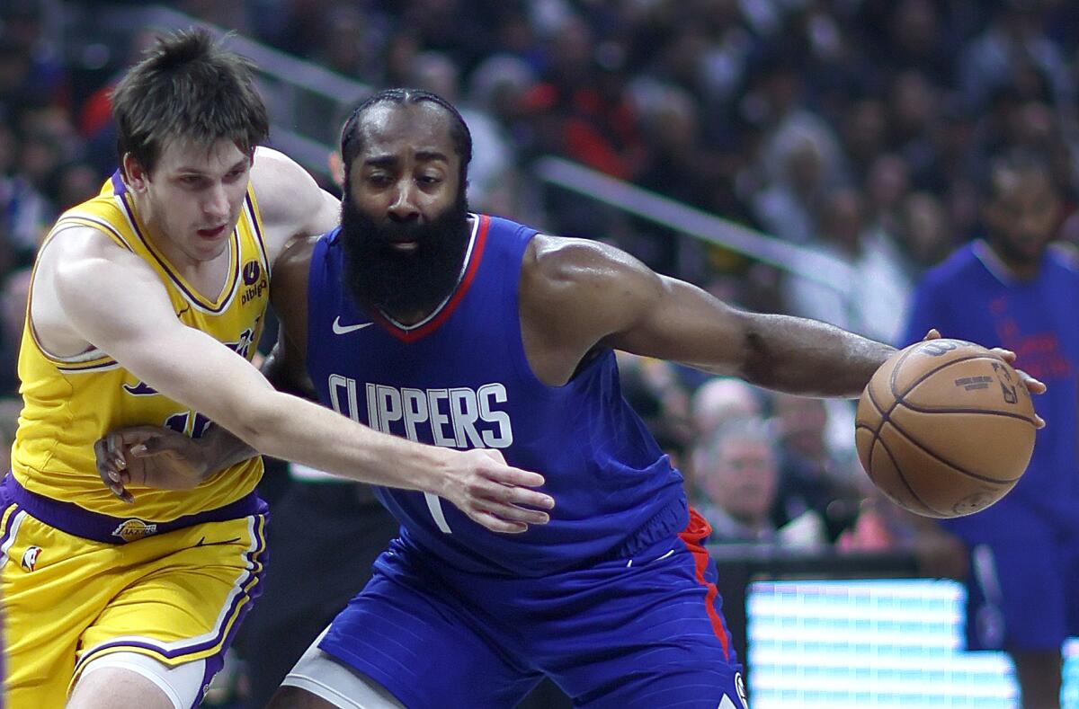 James Harden, right, drives to the hoop as Lakers guard Austin Reaves defends in the first half.