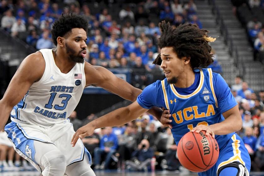 UCLA's Tyger Campbell drives against North Carolina's Jeremiah Francis on Dec. 21 at T-Mobile Arena in Las Vegas.
