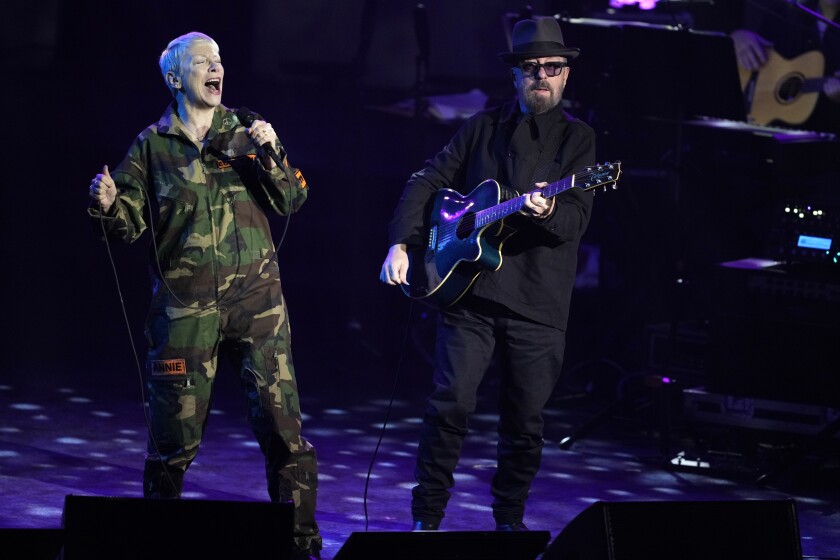 A woman and man sing onstage