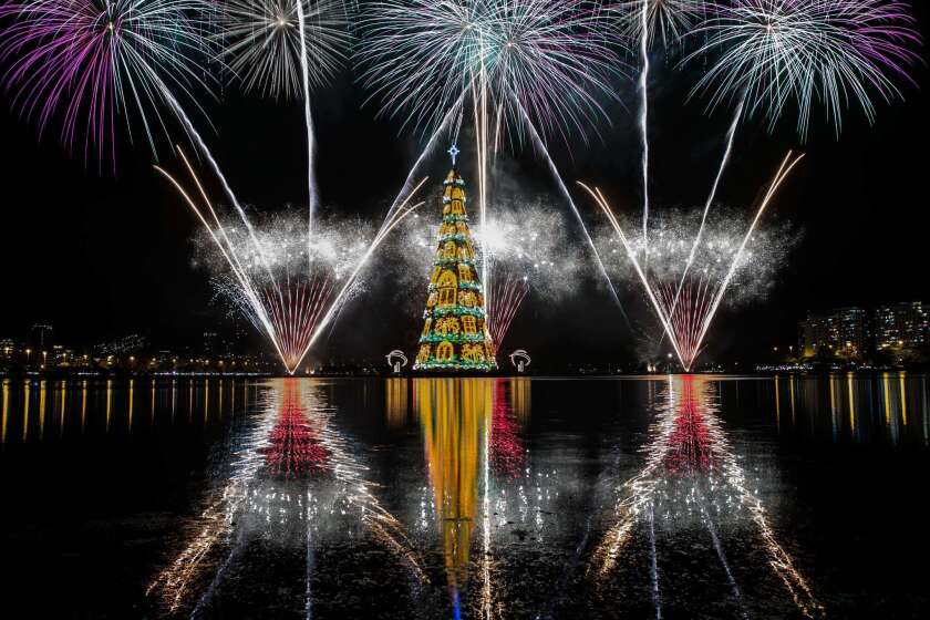 Fireworks are reflected in Rio de Janeiro's lagoon as the floating Christmas tree is lighted Saturday night. The tree is 278 feet tall.
