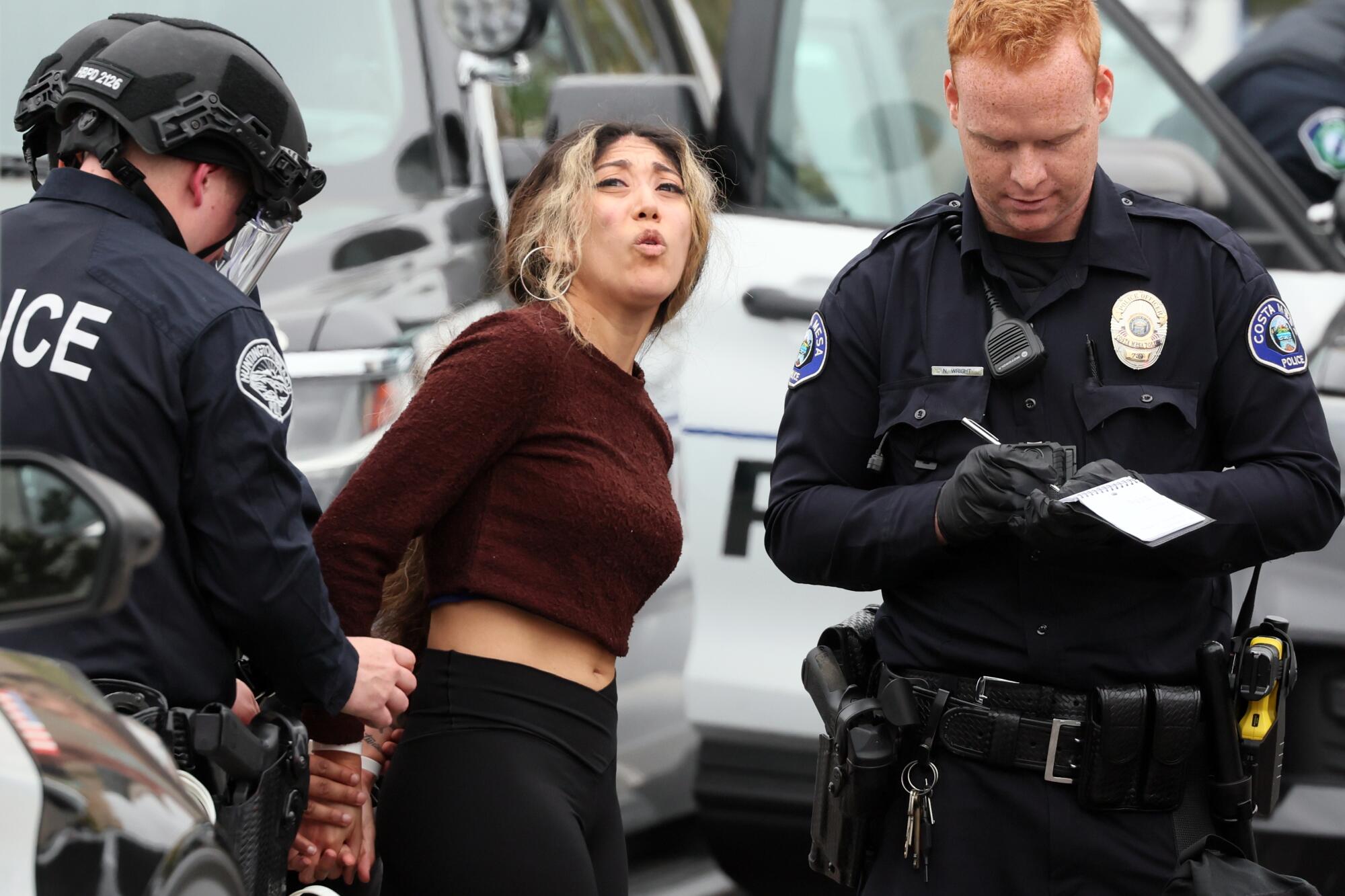 A protester is arrested at UC Irvine as police break up the encampment. 