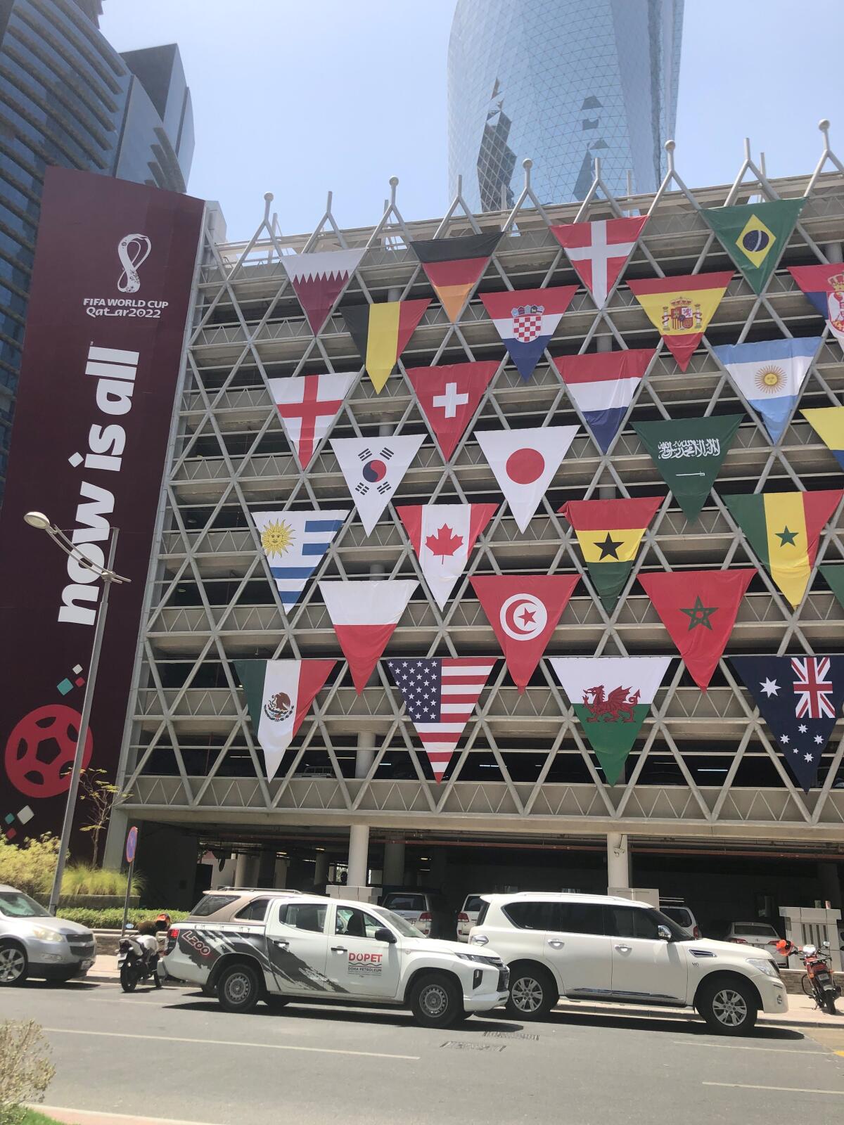 A building in Doha, Qatar, displays flags of teams poised to the play in the FIFA World Cup.