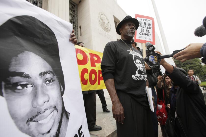 FILE - In this June 13, 2011, file photo, Cephus "Bobby" Johnson stands on the steps of the U.S. District Court building in Los Angeles protesting the release of Johannes Mehserle, the former San Francisco Bay area transit officer who fatally shot Johnson's nephew Oscar Grant. A Northern California prosecutor announced Monday, Oct. 5, 2020, that she will reopen the investigation into the killing of Grant at a train station by a police officer 11 years earlier. Grant, 22, was fatally shot in the back by Bay Area Rapid Transit Officer Johannes Mehserle while he was on the floor of a train station on New Year's Day in 2009. (AP Photo/Nick Ut, File)
