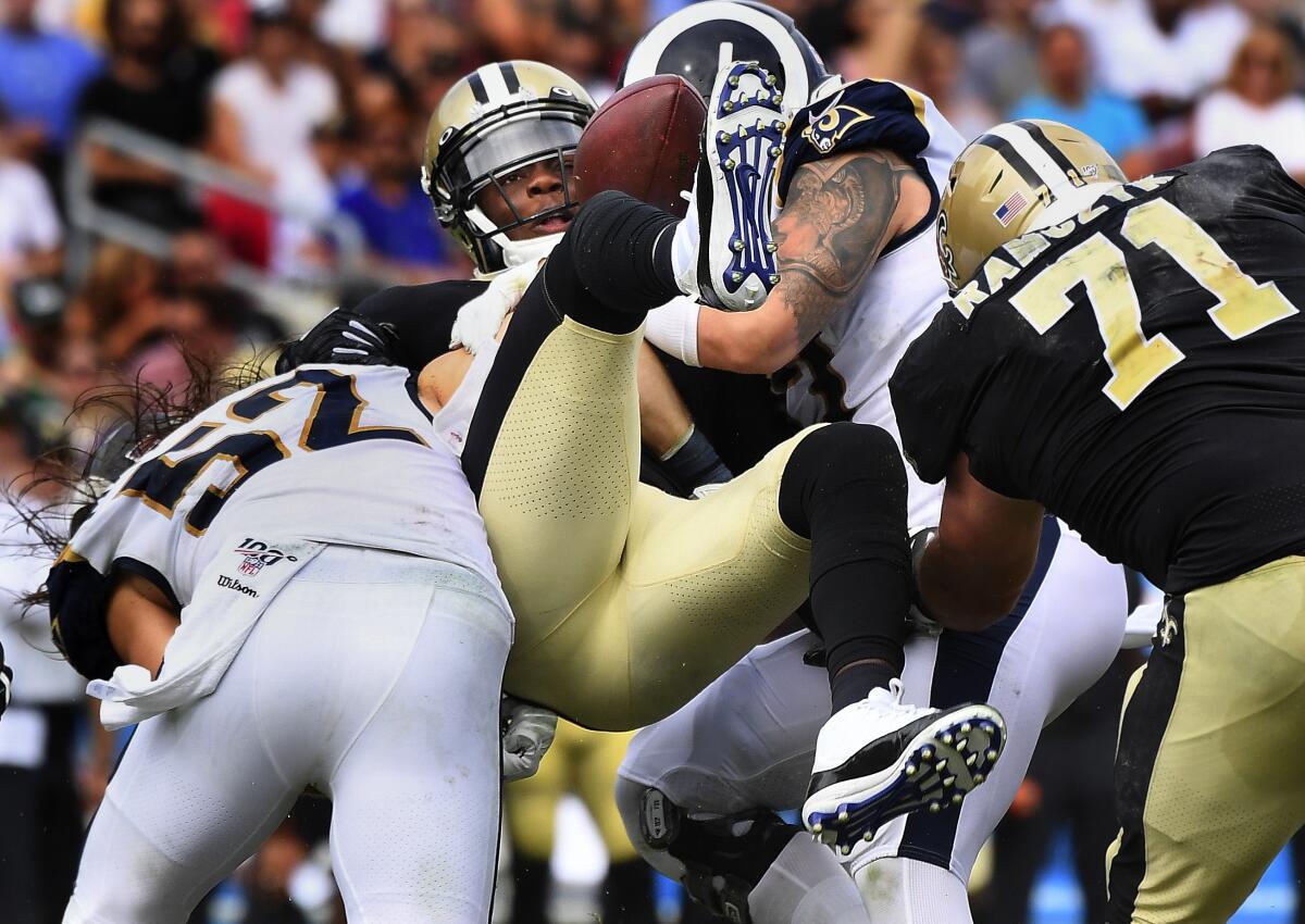 Saints quarterback Teddy Bridgewater fumbles the ball as he is sacked by the Rams' Clay Matthews, left, and Morgan Fox during Sunday's game.