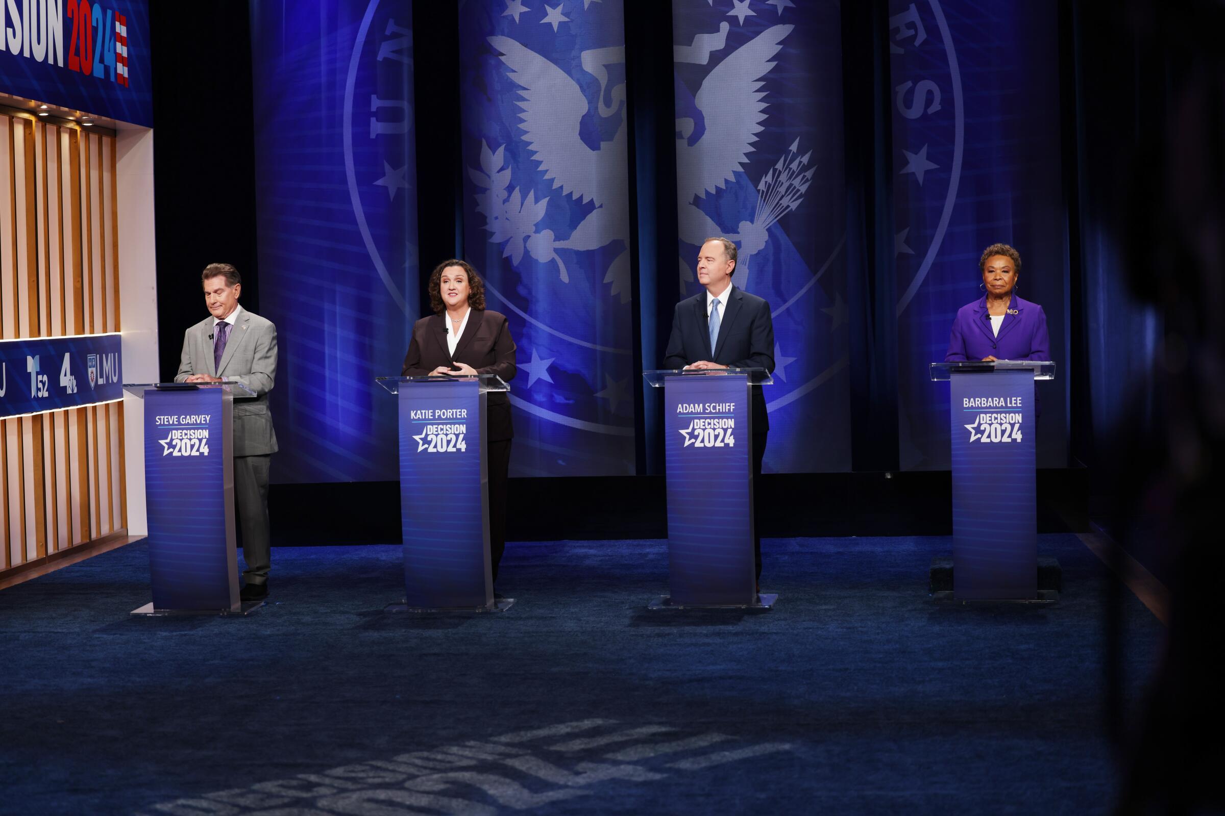 California Senate candidates stand at podiums during a debate. 