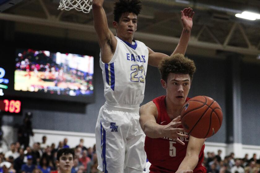 RANCHO SANTA MARGARITA, CA - JANUARY 16, 2019: Mater Dei Devin Askew (5) passes off after driving towards the basket in front of Santa Margarita Max Agbonkpolo (23) during the first half at Santa Margarita High School on January 16, 2019 in Rancho Santa Margarita, California.(Gina Ferazzi/Los AngelesTimes)