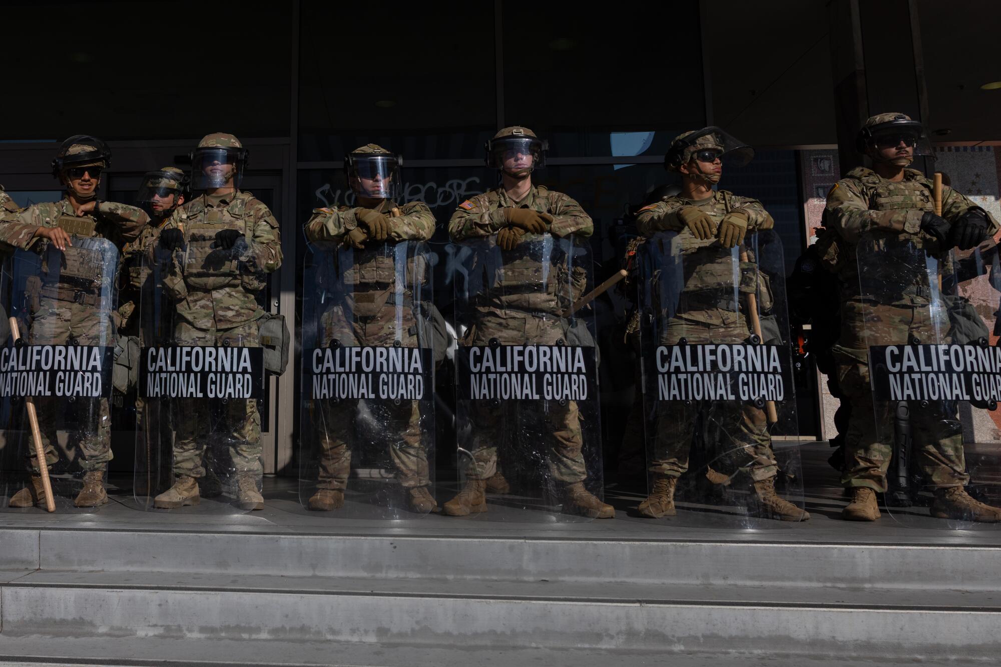 Federal officers and National Guard members stand outside the Federal Building in downtown Los Angeles on Tuesday.