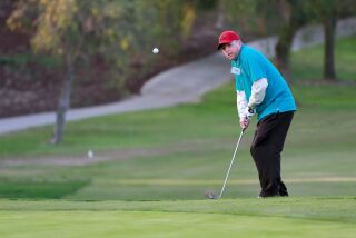 Special Olympics golfer Wes McMorran, 37, chips it in to the putting green during practice at the Bernardo Heights Country Club on Thursday.