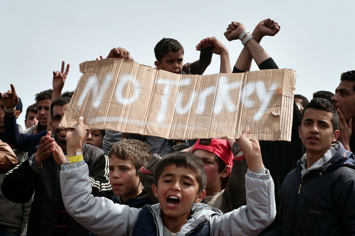 Refugees and migrants who left a registration camp protest at the port of Chios, Greece, on April 3.