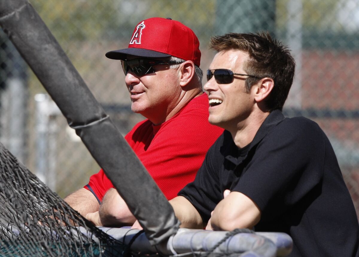 Angels Manager Mike Scioscia and General Manager Jerry Dipoto talk during spring training in 2014.