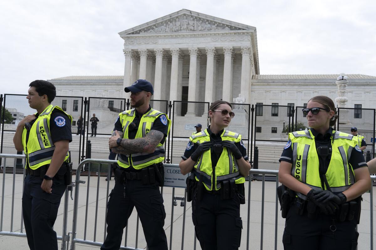 Police in reflective vests stand outside the Supreme Court 