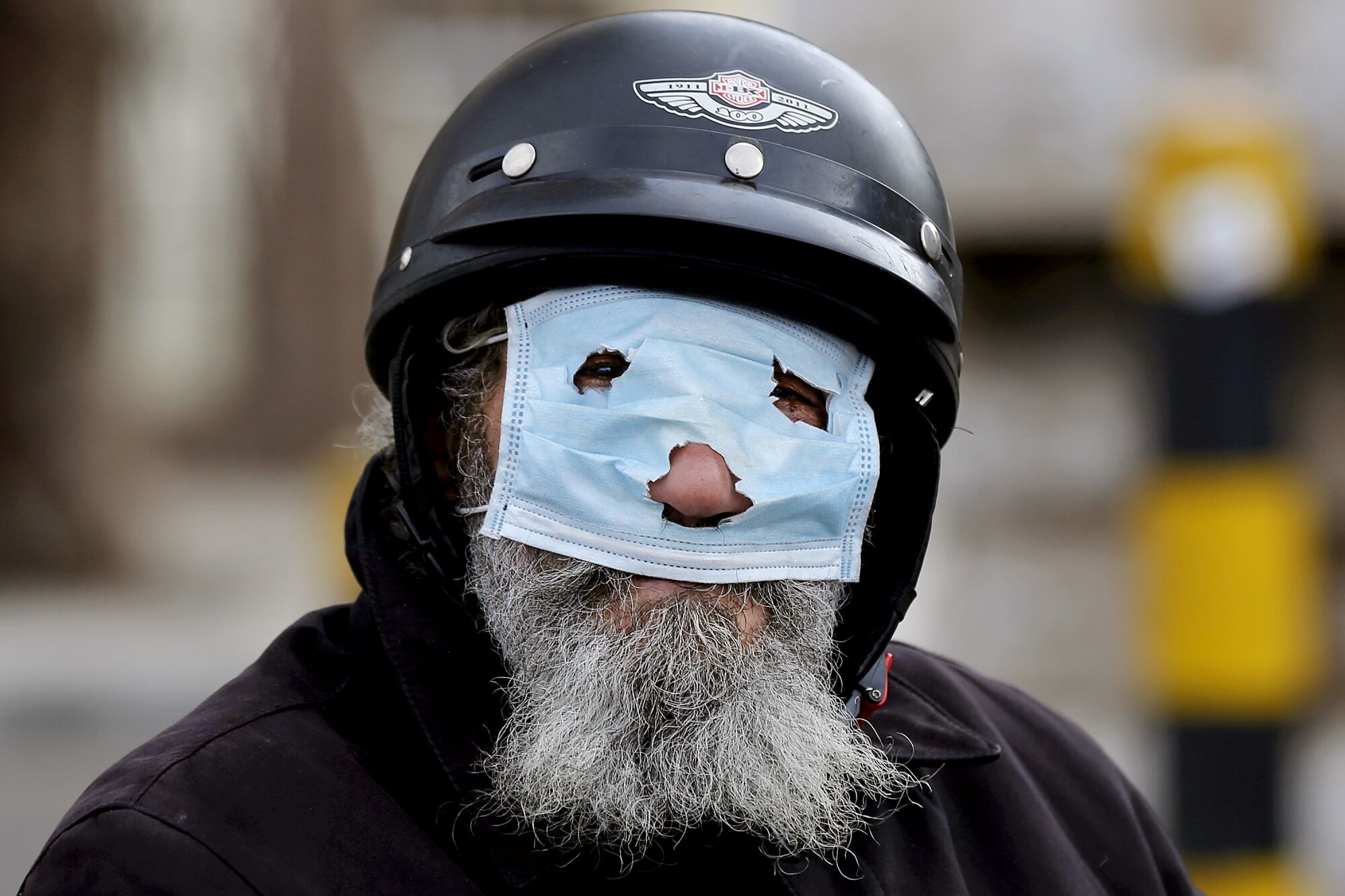 LEBANON: A bearded man covers his face with a punched-out surgical mask in Beirut.