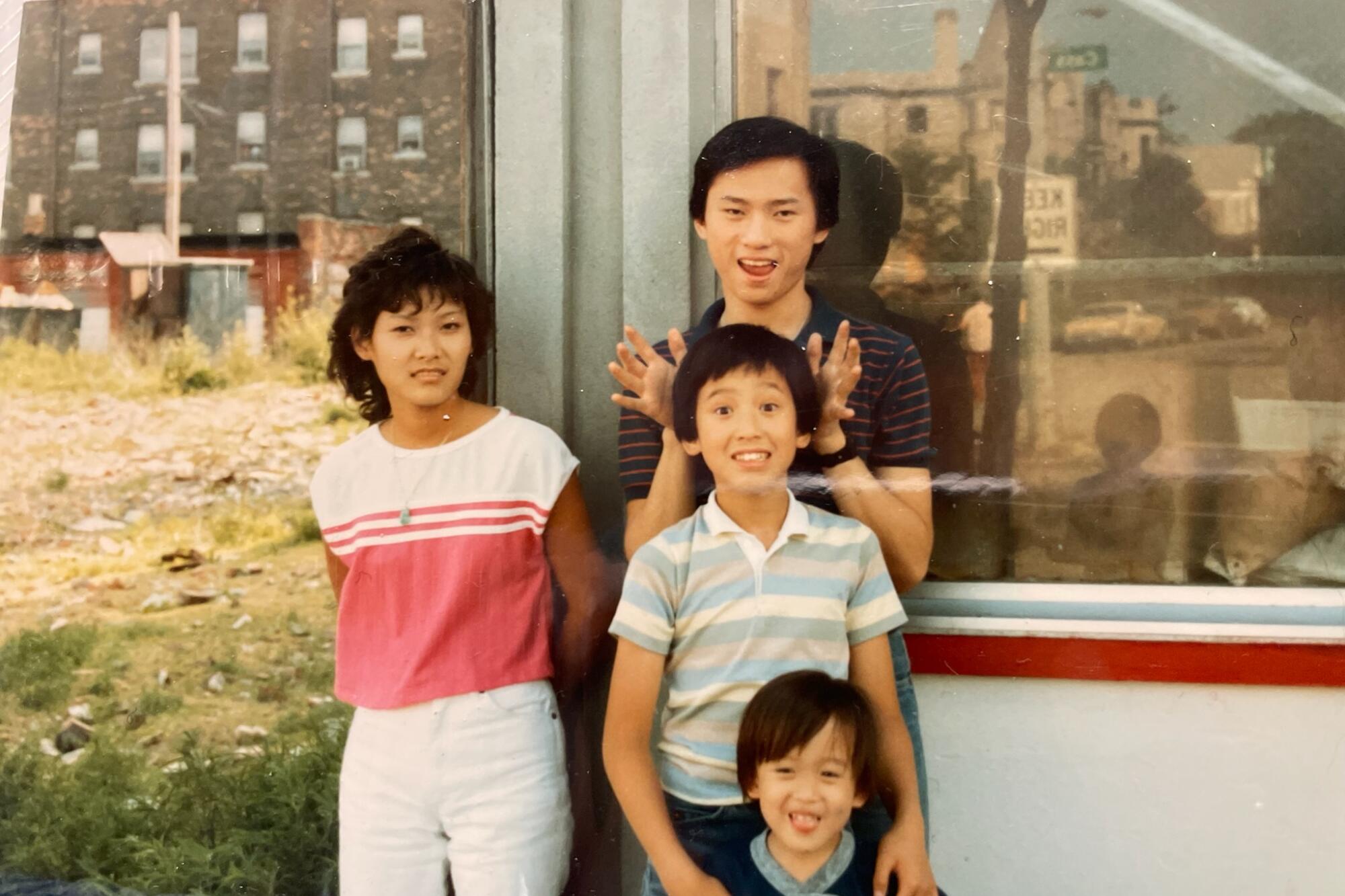 Four kids and teenagers standing in front of a restaurant storefront.
